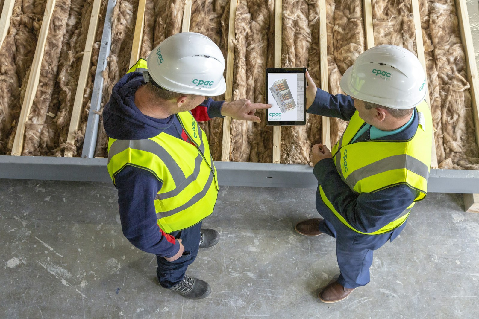 Työnjohtajat tarkastelevat suunnitelmia työmaalla
